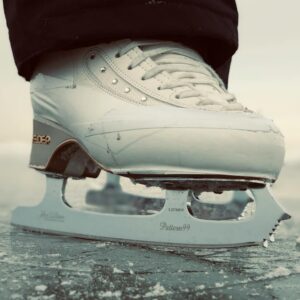 Detailed view of a white ice skate gliding on a frozen surface in Sweden.
