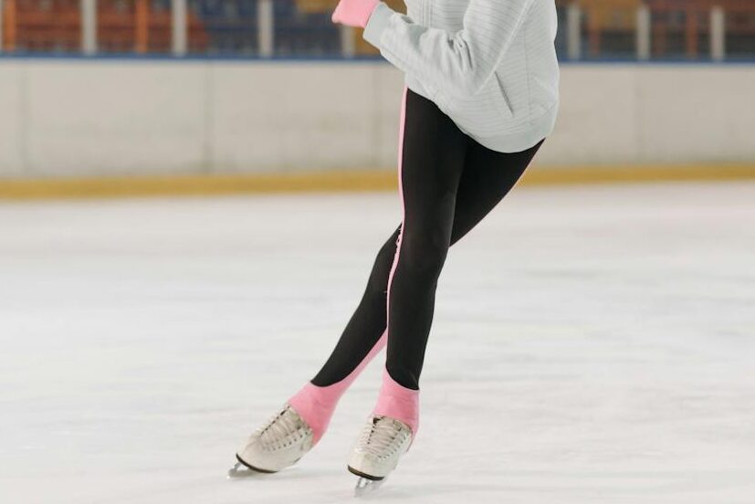 Young figure skater gliding on indoor ice rink. Perfect for sports or lifestyle themes.
